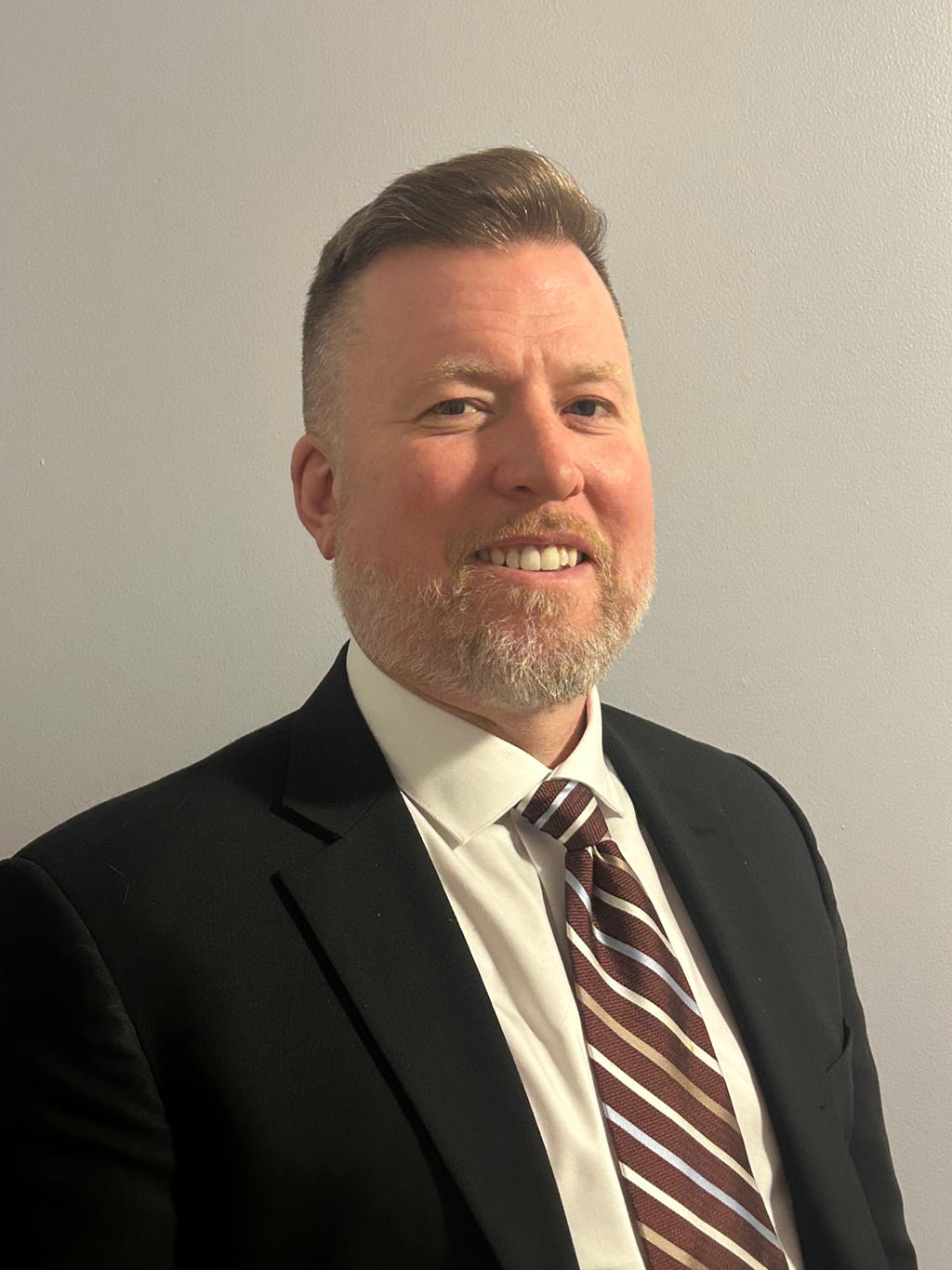Professional man in suit and tie with a beard.